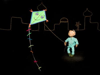 Foto fra forestilling. En dreng/dukke holder en drage.